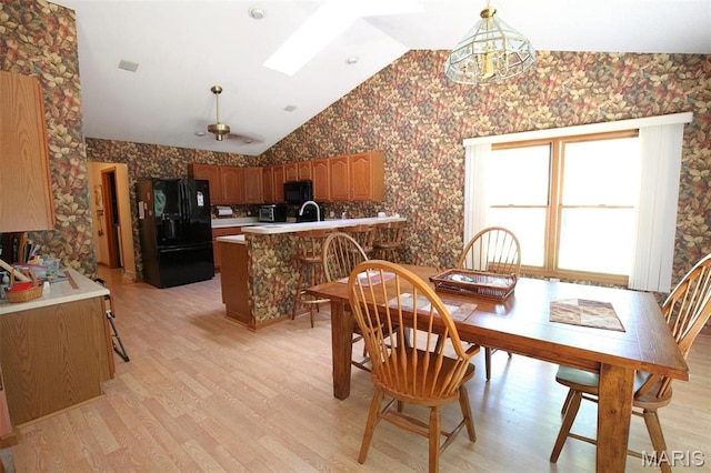 1710 Doe Run Dr, Vandalia, IL 62471 - dining space featuring wallpapered walls, lofted ceiling, light wood finished floors, a chandelier, and a skylight