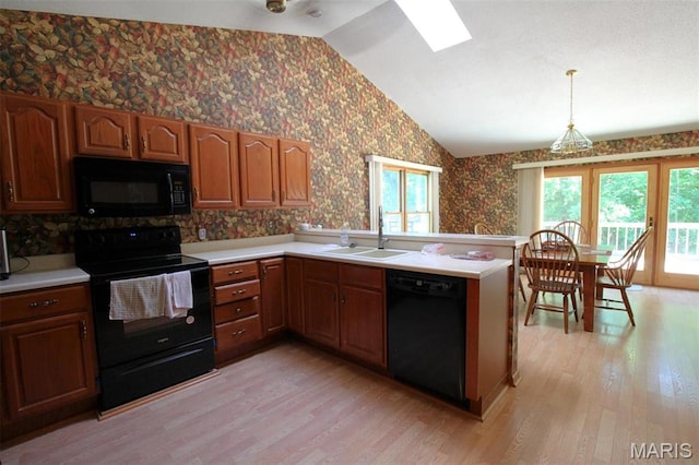 1710 Doe Run Dr, Vandalia, IL 62471 - kitchen with black appliances, wallpapered walls, light wood finished floors, vaulted ceiling, and light countertops