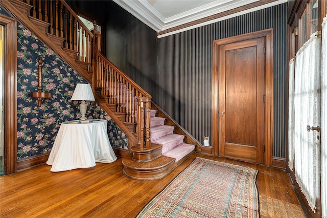 202 Poplar St, Harrisburg, IL 62946 - foyer entrance featuring wood finished floors, wallpapered walls, crown molding, stairs, and baseboards