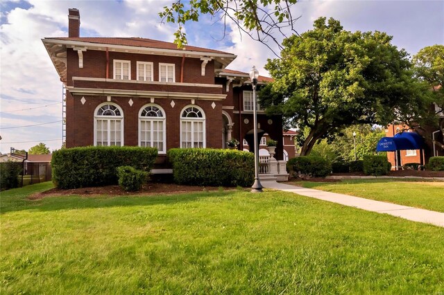 202 Poplar St, Harrisburg, IL 62946 - italianate home with a chimney, a front yard, and brick siding