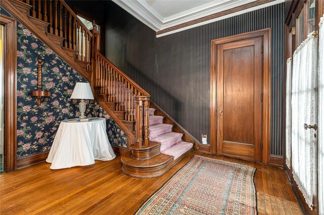202 Poplar St, Harrisburg, IL 62946 - foyer entrance featuring wood finished floors, wallpapered walls, crown molding, stairs, and baseboards
