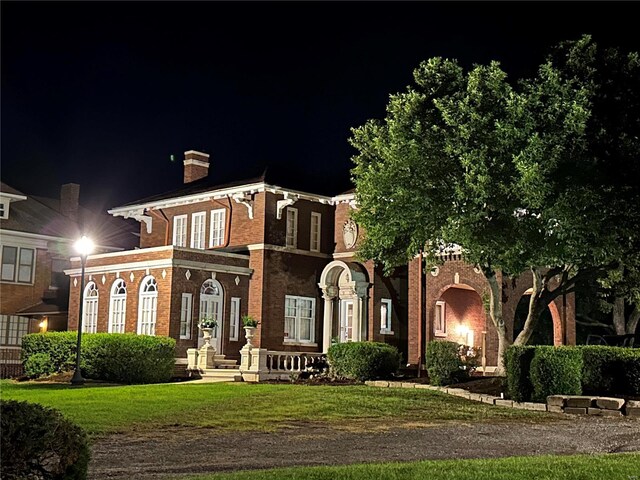 202 Poplar St, Harrisburg, IL 62946 - italianate-style house with a chimney, brick siding, and a lawn