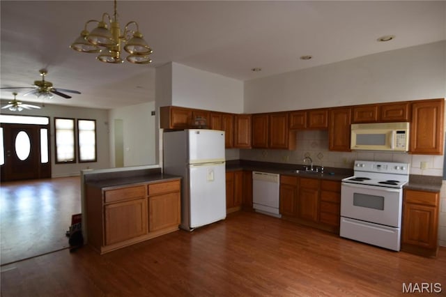 7617 Ivory Ave, Saint Louis, MO 63111 - kitchen with white appliances, dark countertops, brown cabinets, a sink, and a ceiling fan