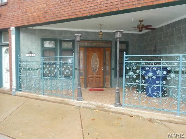 7617 Ivory Ave, Saint Louis, MO 63111 - doorway to property with ceiling fan, brick siding, and a porch