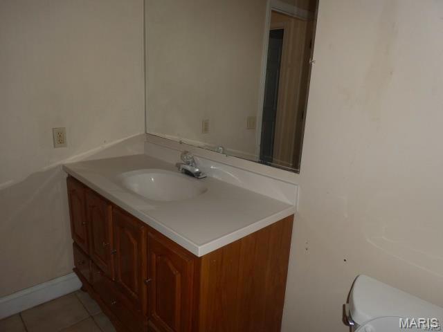 7617 Ivory Ave, Saint Louis, MO 63111 - half bathroom featuring vanity, toilet, and tile patterned floors