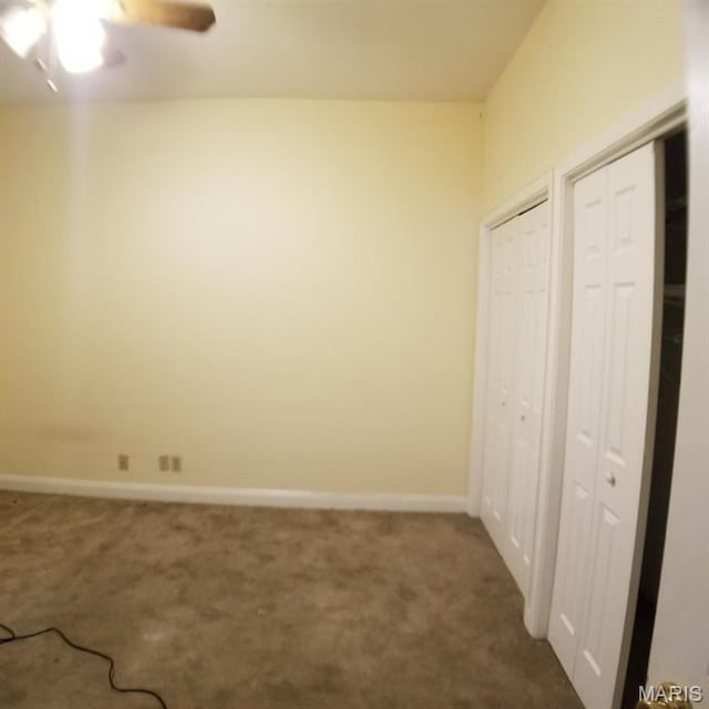 7617 Ivory Ave, Saint Louis, MO 63111 - unfurnished bedroom featuring multiple closets, dark colored carpet, baseboards, and a ceiling fan