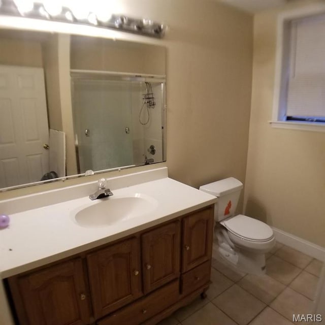 7617 Ivory Ave, Saint Louis, MO 63111 - bathroom with a shower with shower door, tile patterned flooring, vanity, toilet, and baseboards