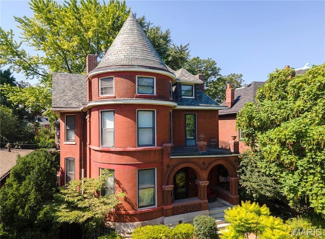 3630 Flad Ave, Saint Louis, MO 63110 - view of front of home featuring a chimney, a high end roof, covered porch, and brick siding