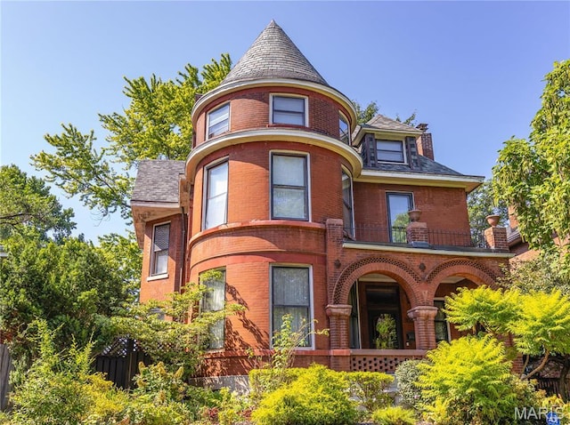 3630 Flad Ave, Saint Louis, MO 63110 - victorian home with a balcony, brick siding, and covered porch