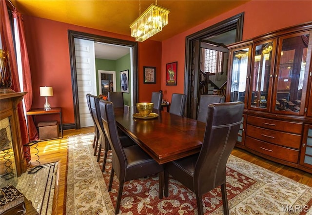 3630 Flad Ave, Saint Louis, MO 63110 - dining room with a chandelier, wood finished floors, and stairs