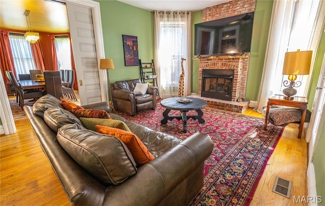 3630 Flad Ave, Saint Louis, MO 63110 - living room featuring wood finished floors, a fireplace, and ceiling fan
