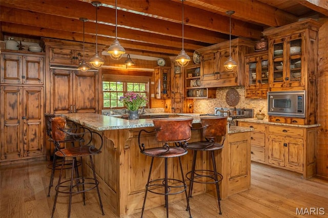 5140 Saint Anns Rd, Washington, MO 63090 - bar area with stainless steel microwave, light wood-style floors, beam ceiling, backsplash, and hanging light fixtures