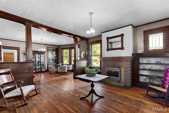 302 E Walsh St, Montgomery City, MO 63361 - living area featuring a chandelier, a textured ceiling, hardwood / wood-style flooring, and a fireplace