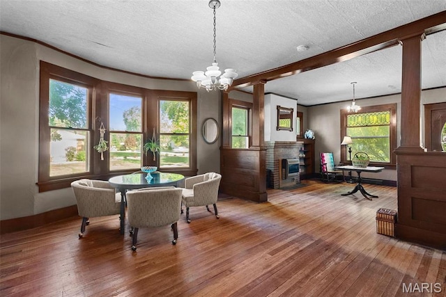 302 E Walsh St, Montgomery City, MO 63361 - dining room with wood-type flooring, a brick fireplace, healthy amount of natural light, and a textured ceiling