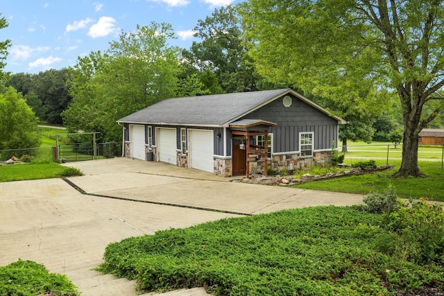 547 County Road 448, Poplar Bluff, MO 63901 - view of front of property with stone siding, a garage, board and batten siding, and view of wooded area
