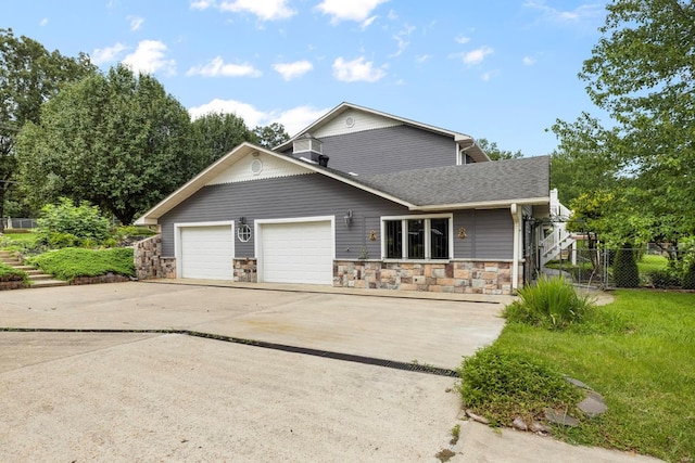 547 County Road 448, Poplar Bluff, MO 63901 - view of front of house featuring stone siding, driveway, a garage, fence, and roof with shingles