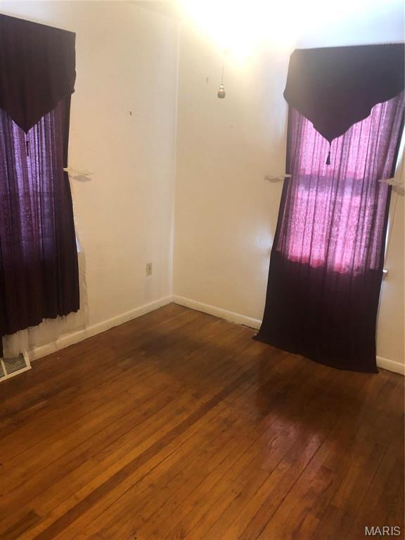 837 N 70th St E, St Louis, IL 62203 - unfurnished room featuring hardwood / wood-style floors and baseboards