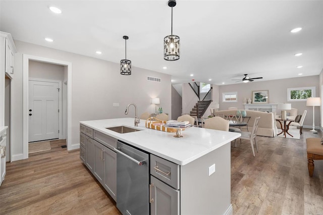 8817 Moritz Ave, Saint Louis, MO 63144 - kitchen featuring a sink, gray cabinetry, stainless steel dishwasher, a ceiling fan, and a center island with sink