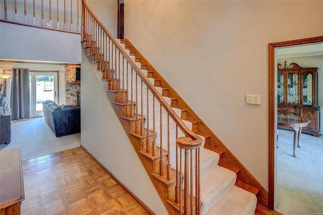 stairs featuring a towering ceiling and baseboards