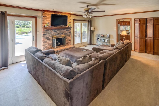 living room featuring light colored carpet, crown molding, a brick fireplace, and ceiling fan