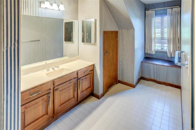 bathroom with wallpapered walls, baseboards, and vanity