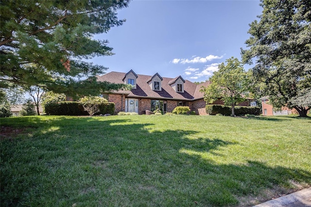 cape cod home with a front lawn and brick siding