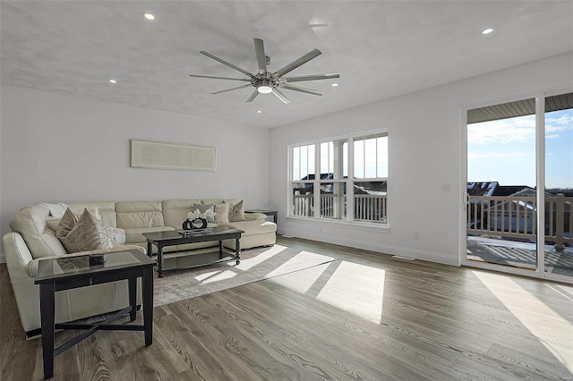living area with plenty of natural light, recessed lighting, a ceiling fan, wood finished floors, and baseboards