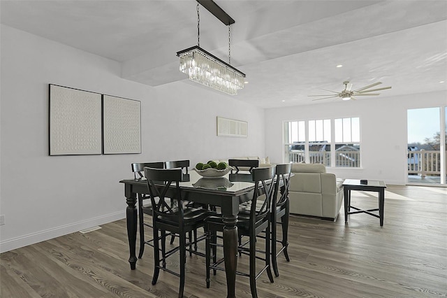 dining room with a chandelier, wood finished floors, baseboards, and ceiling fan