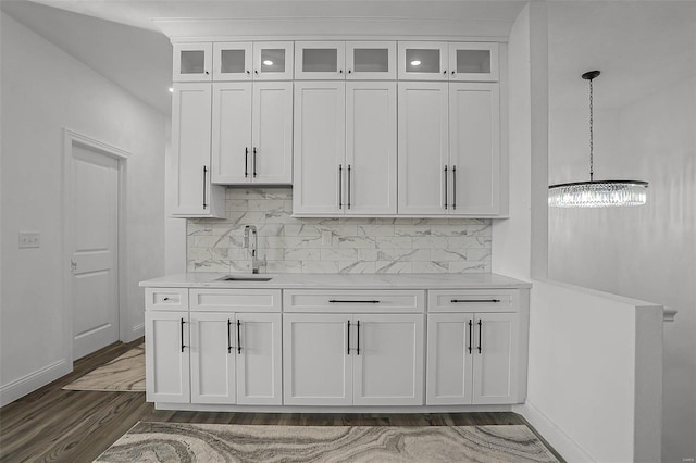 kitchen featuring a sink, white cabinetry, light countertops, and decorative backsplash