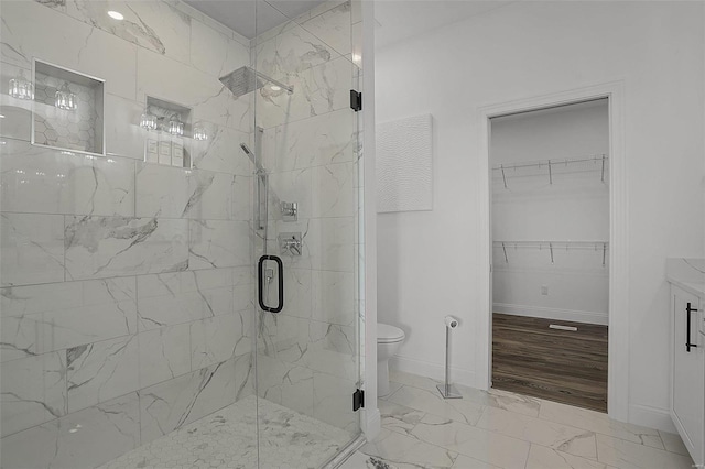 bathroom featuring a marble finish shower, marble look tiles, baseboards, and toilet