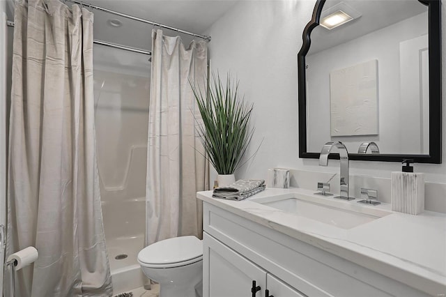 bathroom with toilet, a shower stall, and vanity