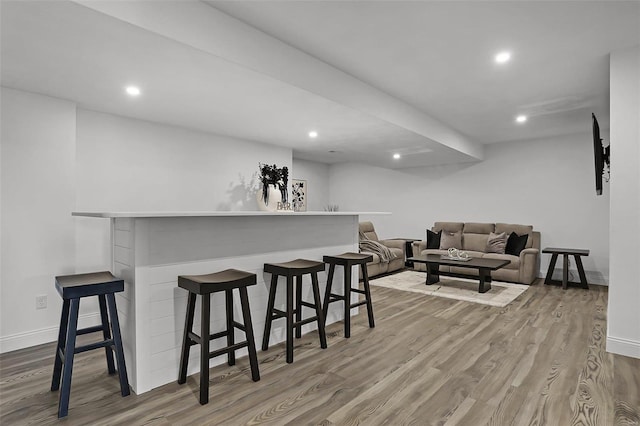 indoor dry bar with wood finished floors, baseboards, and recessed lighting