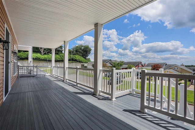 wooden deck with a residential view and a water view
