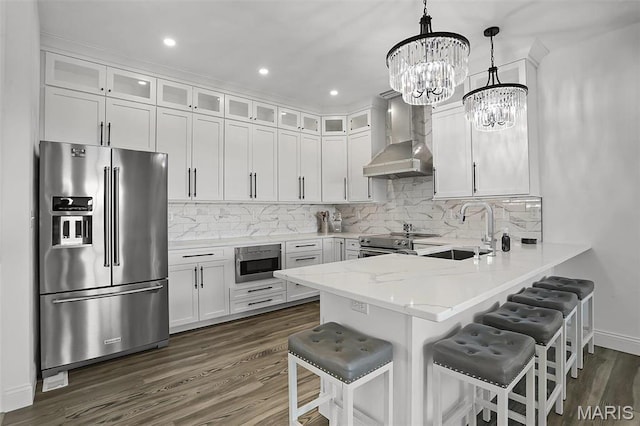 310 Captains Ct, Grafton, IL 62037 - kitchen with appliances with stainless steel finishes, wall chimney range hood, a sink, a peninsula, and a chandelier
