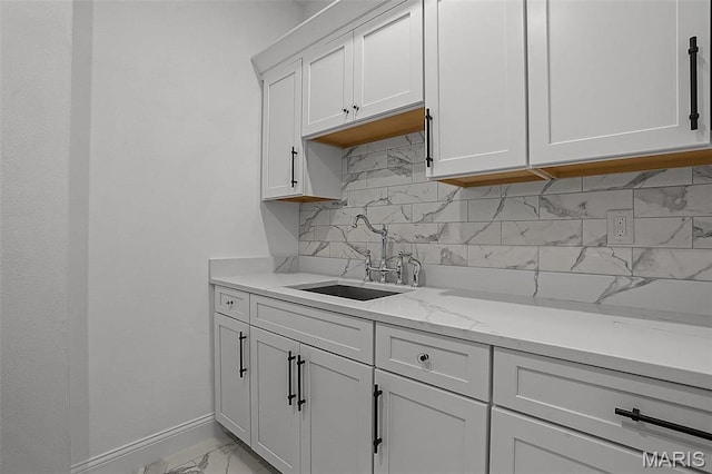 310 Captains Ct, Grafton, IL 62037 - kitchen featuring a sink, light marble finish flooring, backsplash, baseboards, and white cabinetry