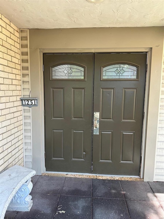 property entrance featuring brick siding