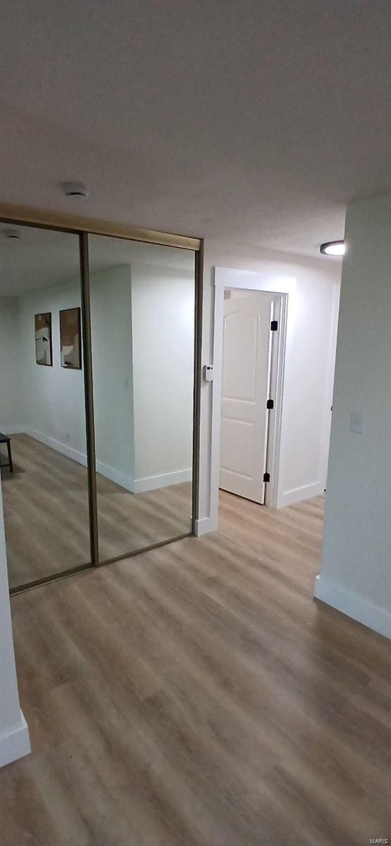 unfurnished bedroom featuring wood finished floors and baseboards