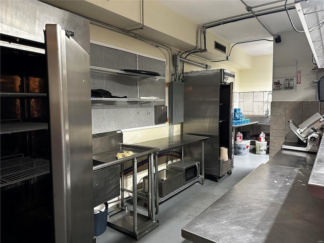 156 S Main St, Ironton, MO 63650 - kitchen featuring stainless steel counters, finished concrete floors, electric panel, and freestanding refrigerator