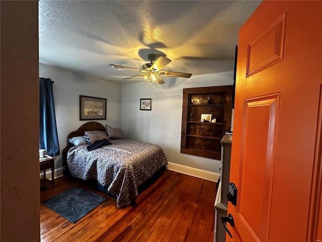 156 S Main St, Ironton, MO 63650 - bedroom featuring dark wood finished floors, a textured ceiling, baseboards, and a ceiling fan