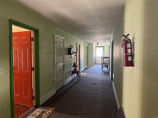 156 S Main St, Ironton, MO 63650 - hallway featuring a textured wall, a textured ceiling, dark carpet, and baseboards