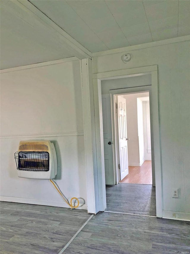 hallway with heating unit and wood finished floors