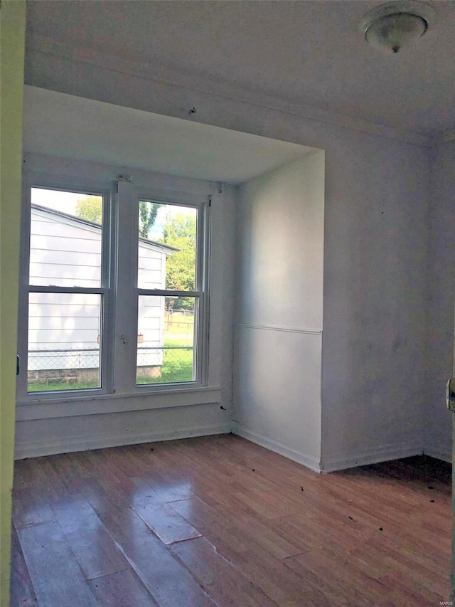 unfurnished room with wood-type flooring and baseboards
