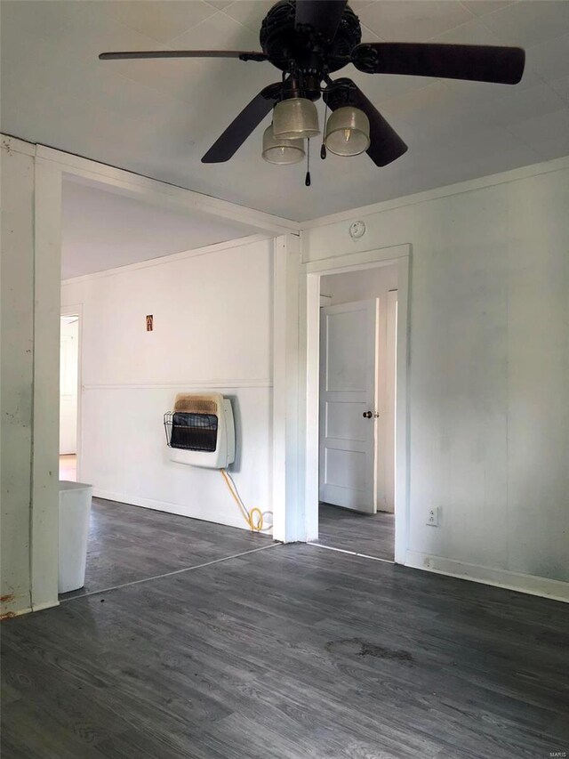 unfurnished room featuring heating unit, ceiling fan, wood finished floors, baseboards, and a smoke detector