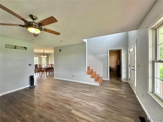6624 State Route C, Saint Genevieve, MO 63670 - unfurnished living room with a textured ceiling, dark wood-style flooring, stairway, a chandelier, and ceiling fan