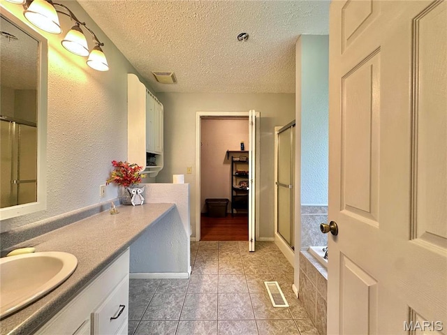 6624 State Route C, Saint Genevieve, MO 63670 - full bath with vanity, a textured ceiling, a stall shower, tile patterned floors, and tiled tub