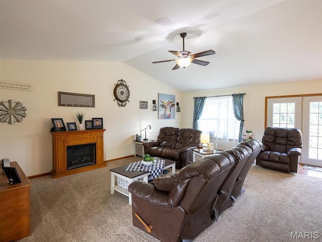 carpeted living area featuring vaulted ceiling, a ceiling fan, a glass covered fireplace, and baseboards