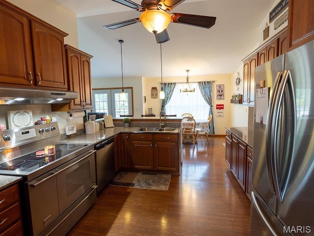 kitchen featuring appliances with stainless steel finishes, under cabinet range hood, a sink, a peninsula, and dark wood-style floors