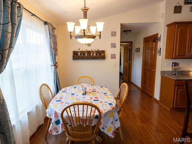 dining space featuring dark wood-style floors, a chandelier, and baseboards