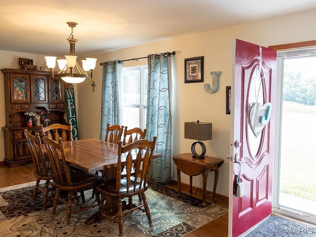 dining room with a chandelier, wood finished floors, plenty of natural light, and baseboards