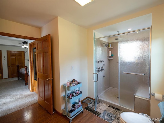 bathroom featuring a stall shower, wood finished floors, and a ceiling fan